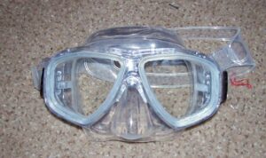 Photograph of clear plastic goggles on sand